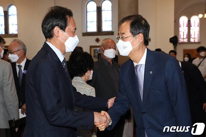 한덕수 국무총리와 우상호 더불어민주당 의원(왼쪽)이 10일 오전 서울 중구 대한성공회 서울주교성당에서 열린 제35주년 6.10 민주항쟁 기념식에서 인사나누고 있다. 2022.6.10/뉴스1 © News1 이광호 기자