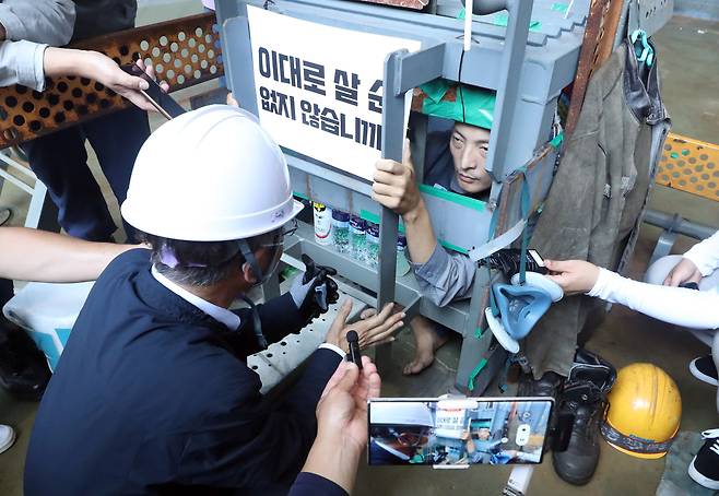 이정식 고용노동부 장관이 19일 오후 경남 거제시 아주동 대우조선해양 옥포조선소 파업 현장을 방문해 조선소 독 화물창 바닥에 가로, 세로, 높이 각 1ｍ 철 구조물 안에서 농성 중인 유최안 금속노조 거제통영고성 조선하청지회 부지회장과 면담하고 있다. /연합뉴스