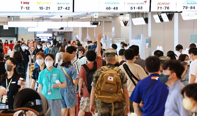 코로나19 확산세가 거세지는 가운데 15일 오전 서울 강서구 김포공항 국내선 청사에서 이용객들이 탑승 수속을 밟고 있다. 연합뉴스 제공