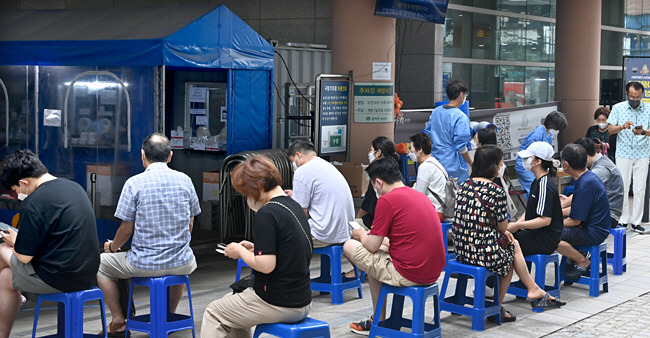 다시 길어지는 검사 대기줄 : 20일 오전 서울 관악구 봉천동 관악구보건소에서 주민들이 선별진료소 앞에 마련된 간이의자에 앉아 코로나19 검사 순서를 기다리고 있다.    신창섭 기자