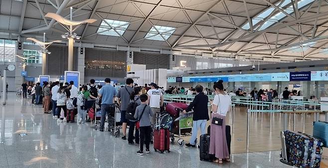 인천공항 제1여객터미널 3층 출국장에서 여행객들이 긴 줄을 서서 탑승수속을 기다리고 있다.