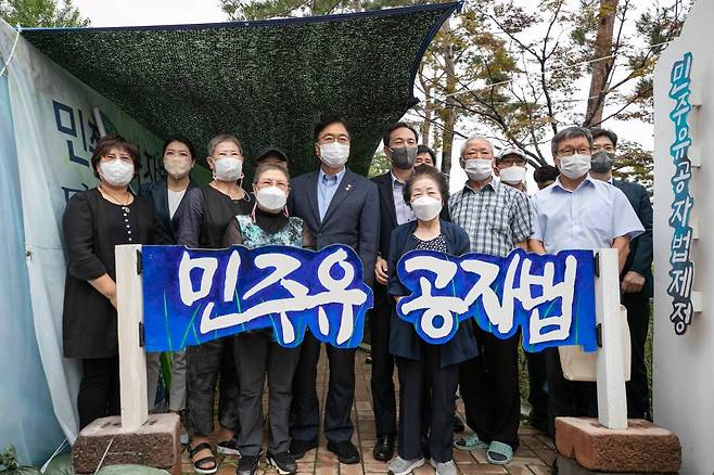 [서울=뉴시스] 김선웅 기자 = 더불어민주당 우상호 비상대책위원장(가운데)과 우원식 의원이 21일 오전 서울 여의도 국회 정문 앞에서 ‘민주유공자법 제정’을 촉구하며 9개월째 농성중인 전국민족민주유가족협의회(유가협)와 민주유공자법제정추진단의 천막농성장을 방문해 유족들과 기념촬영을 하고 있다.   (공동취재사진) 2022.07.21.