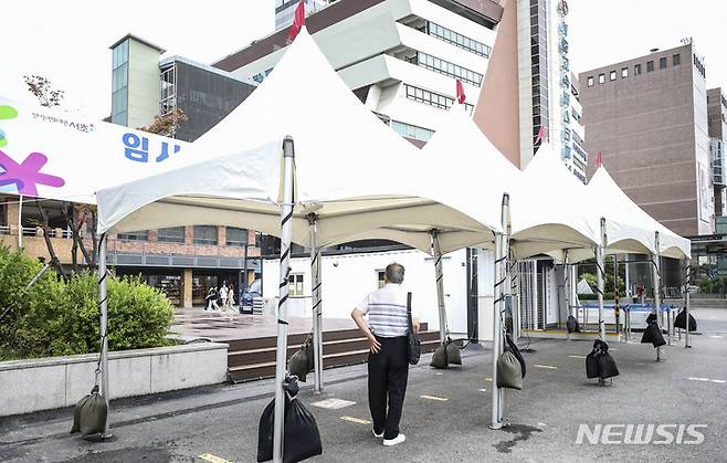 [서울=뉴시스] 김근수 기자 = 국내 코로나19 재확산에 따라 서울 시내 코로나19 임시선별검사소가 재개장을 하루 앞둔 21일 오후 서울시 서초구 서울고속버스터미널에서 한 시민이 설치된 임시선별검사소를 보고 있다. 2022.07.21. ks@newsis.com