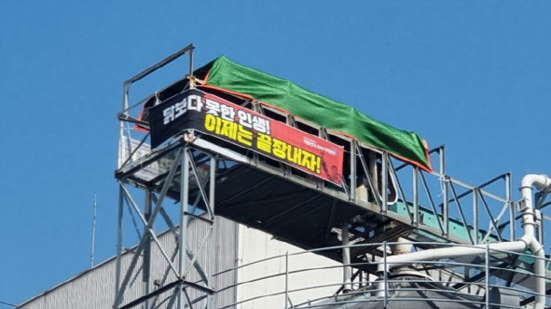 22일 전북 군산시 닭고기 가공업체 참프레 공장에 있는 30ｍ 높이 저장고에서 민주노총 공공운수노조 화물연대 소속 운수기사 조합원들이 고공농성을 벌이고 있다.(사진=민주노총 공공운수노조)