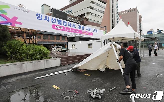 운영 재개를 하루 앞둔 지난 21일 서울 서초구 고속버스터미널 임시선별검사소에서 관계자들이 그늘막 설치 및 운영준비를 하고 있다. 2022.7.21/뉴스1 © News1 박지혜 기자