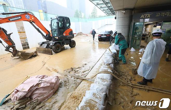 수도권 지역에 호우주의보가 내려진 13일 오후 경기 광명시 일직동 경부선(KTX) 광명역에 인근 신안산선 공사현장의 토사와 흙탕물이 지하 승강장으로 유입돼 현장 관계자들이 토사를 치우고 있다. 2022.7.13/뉴스1 © News1 김영운 기자