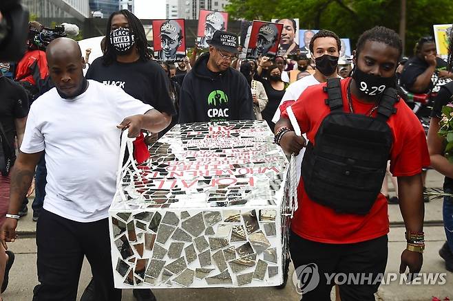 '플로이드 사망 1주기' 추모행진하는 미 시민들 미국 경찰의 폭력으로 숨진 흑인 남성 조지 플로이드의 1주기를 이틀 앞둔 2021년 5월 23일(현지시간) 미네소타주 미니애폴리스에서 시민들이 모형 관을 들고 플로이드를 추모하는 행진을 벌이고 있다. [EPA=연합뉴스 자료사진, 재판매 및 DB 금지]