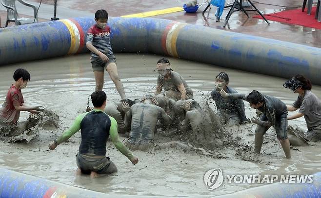 신나는 머드 체험 (보령=연합뉴스) 조성민 기자 = 충남 보령 대천해수욕장 일대에서 열리고 있는 '2022 보령해양머드박람회'의 인기관인 머드체험장에서 24일 입장객들이 머드 체험을 하고 있다. 2022.7.24 min365@yna.co.kr