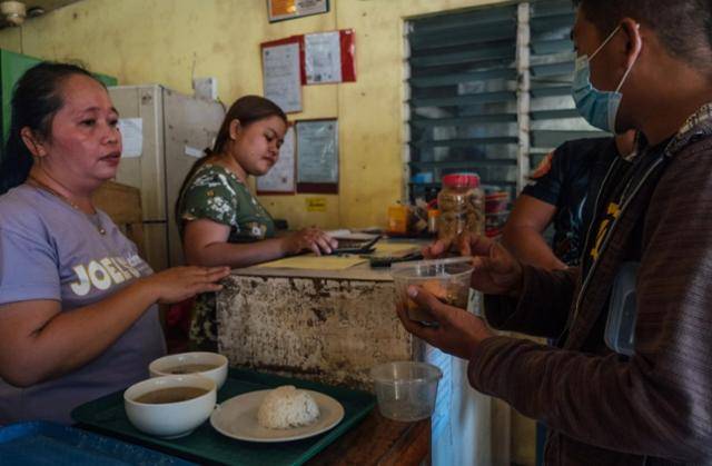 필리핀 시키호르섬의 한 가게에서 음식 포장을 원하는 시민이 직접 가져온 용기에 음식물을 받아가고 있다. SCMP 캡처