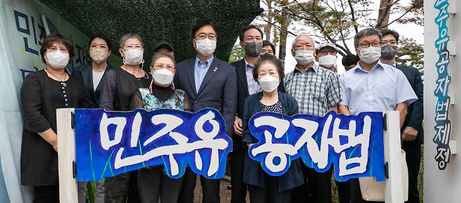 더불어민주당 우상호 비상대책위원장(왼쪽에서 여섯번째)과 우원식 의원(다섯번째)이 지난 21일 국회 정문 앞에서 민주유공자법 제정을 촉구하며 9개월째 농성 중인 유가협 회원들과 사진을 찍고 있다. 국회사진기자단