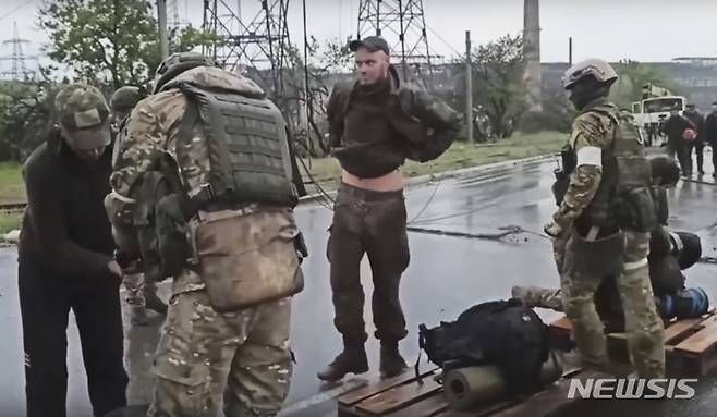 [마리우폴=AP/뉴시스] 19일(현지시간) 우크라이나 동부 도네츠크인민공화국(DPR) 산하 마리우폴에서 러시아 군인들이 아조우스탈 제철소에서 나온 우크라이나 군인들의 몸을 수색하고 있다. 2022.05.20.