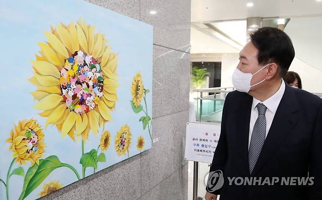 출근길 발달장애 아티스트 작품 살피는 윤 대통령 (서울=연합뉴스) 서명곤 기자 = 윤석열 대통령이 25일 오전 서울 용산 대통령실 청사로 출근하며 희망, 도약, 통합 메시지를 담은 발달장애 아티스트들의 작품을 살펴보고 있다. 2022.7.25  [대통령실통신사진기자단] seephoto@yna.co.kr