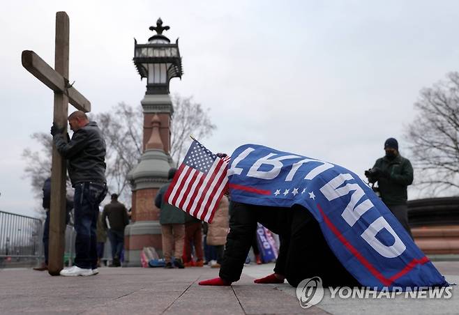 1월6일 의회 습격 당시 십자가에 절하는 트럼프 지지자들 [AFP 게티이미지=연합뉴스 자료사진. 재판매 및 DB 금지]