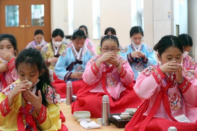 지난 25일 초등학생 40명이 부산 동래구 충렬사에서 열린 '초등학생 여름방학 전통문화 체험교실'에 참여한 모습. 아이들은 한복을 입고 다도 예절을 배우고 있다. 부산=뉴시스