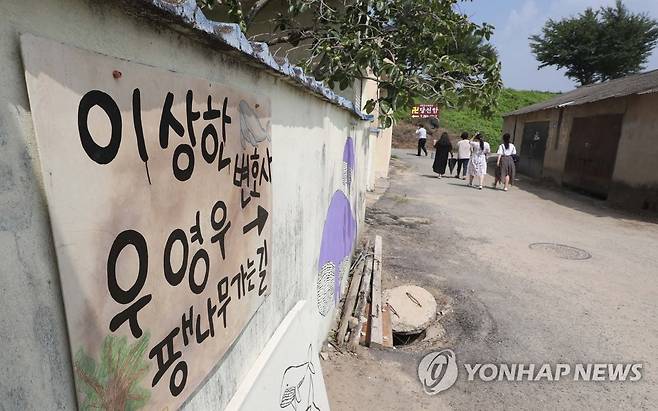 '이상한 변호사 우영우' 팽나무 마을 (창원=연합뉴스) 김동민 기자 = 26일 오후 경남 창원시 의창구 대산면 동부마을에 우영우 나무(창원북부리 팽나무) 위치를 알리는 벽화가 그려져 있다. 이 나무는 ENA 드라마 '이상한 변호사 우영우'에 '소덕동 팽나무'로 등장했고, 최근 온·오프라인에서 큰 인기를 끌고 있다. 2022.7.26 image@yna.co.kr