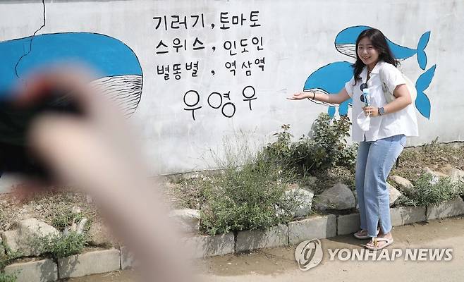 '이상한 변호사 우영우' 인증샷 (창원=연합뉴스) 김동민 기자 = 26일 오후 경남 창원시 의창구 대산면 동부마을에 '우영우 나무(창원북부리 팽나무)'를 기념하는 벽화가 그려져 있다.
    이 나무는 ENA 드라마 '이상한 변호사 우영우'에 '소덕동 팽나무'로 등장했고, 최근 온·오프라인에서 큰 인기를 끌고 있다. 2022.7.26 image@yna.co.kr