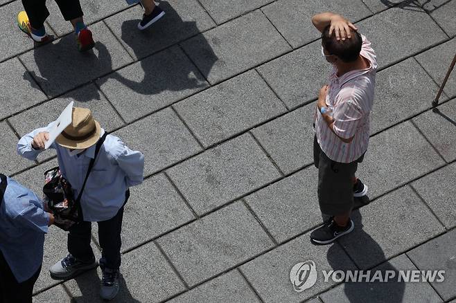 만만치 않은 중복 더위 (서울=연합뉴스) 김주성 기자 = 중복(中伏)인 26일  서울 종로구 탑골공원 원각사 노인 무료급식소 앞에서 노인들이 따가운 햇볕을 가린 채 배식 순서를 기다리고 있다. 2022.7.26 utzza@yna.co.kr