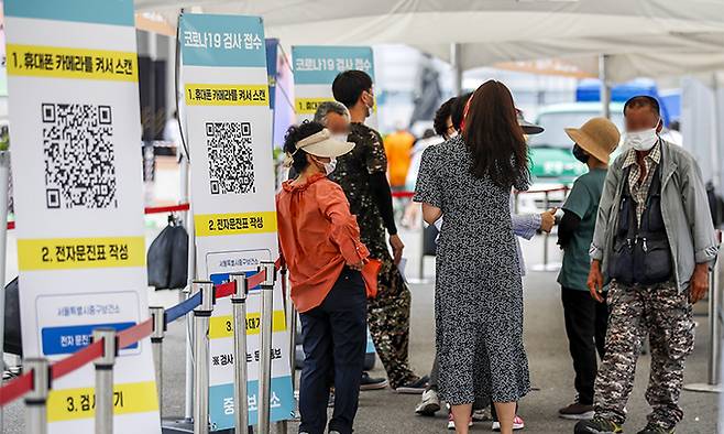 27일 서울 중구 서울역광장에 설치된 임시선별검사소를 찾은 시민들이 검사를 받기 위해 줄 서 있다. 뉴시스