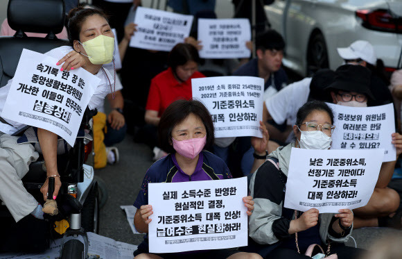 기초생활보장법 바로세우기 공동행동 등 시민단체 회원들이 지난 25일 정부세종청사 보건복지부 앞에서 생계 급여 등 정부 복지사업의 기준인 ‘중위소득’을 현실에 맞게 올려달라고 요구하고 있다.  연합뉴스