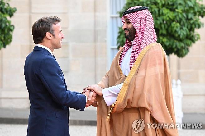 사우디 왕세자와 악수하는 프랑스 대통령 (파리 AFP=연합뉴스) 에마뉘엘 마크롱(왼쪽) 프랑스 대통령이 28일(현지시간) 파리 엘리제궁을 찾은 무함마드 빈 살만 사우디아라비아 왕세자와 악수를 하고 있다. 2022.7.29 photo@yna.co.kr