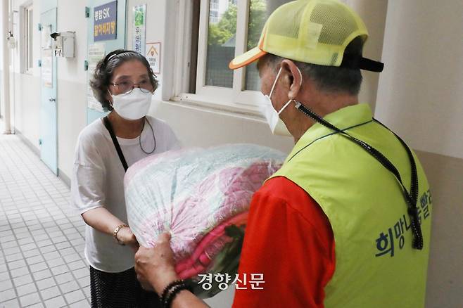 서울 성북구 노인일자리 희망나눔빨래방 사업에 팀장으로 참여하고 있는 김치원씨(79·오른쪽)가 19일 지역 주민 김완자씨(81)에게 빨래를 전달하고 있다. 한수빈 기자