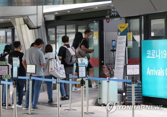 지난 27일 오후 인천국제공항 제1여객터미널 입국자 전용 코로나 검사센터 앞에서 해외 입국자들이 검사를 받기 위해 안내를 받고 있다. 연합뉴스 제공.