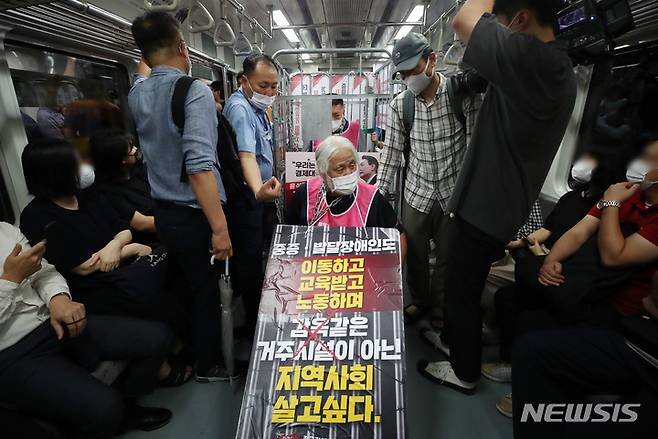 [서울=뉴시스] 김진아 기자 = 전국장애인차별철폐연대가 1일 오전 서울 종로구 5호선 광화문역에서 열린 '제34차 출근길 지하철탑니다'에서 지하철 승하차 시위를 하고 있다. 전장연은 내년도 본예산에 장애인 권리 예산 반영, 장애인 권리 4대 법률 제개정, 서울시의 장애인 탈시설 지원 조례 재정 등을 요구하며 지난해 12월부터 출근길 지하철 선전전을 진행하고 있다. 2022.08.01. bluesoda@newsis.com