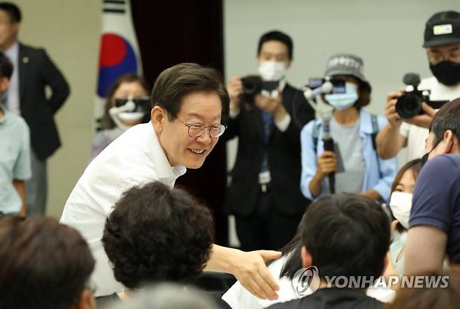 토크 콘서트 참석자와 악수하는 이재명 후보 (강릉=연합뉴스) 유형재 기자 = 더불어민주당 이재명 당 대표 후보가 30일 강원 강릉시 녹색도시체험센터를 방문해 토크 콘서트에 앞서 참석자와 악수하고 있다. 2022.7.30 yoo21@yna.co.kr