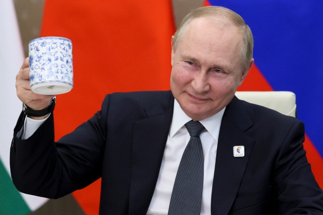 블라디미르 푸틴 러시아 대통령이 지난 6월 모스크바에서 열린 제14차 브릭스(BRICS) 국가 비즈니스 포럼 개막식에 화상으로 참석하며 건배하고 있다. 모스크바/크렘린궁 제공·연합뉴스