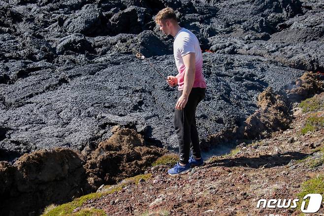 4일(현지시간) 한 남자가 아이슬란드 파그라달스피아들 화산에서 마시멜로를 굽고 있다. ⓒ AFP=뉴스1 ⓒ News1 박기현 기자