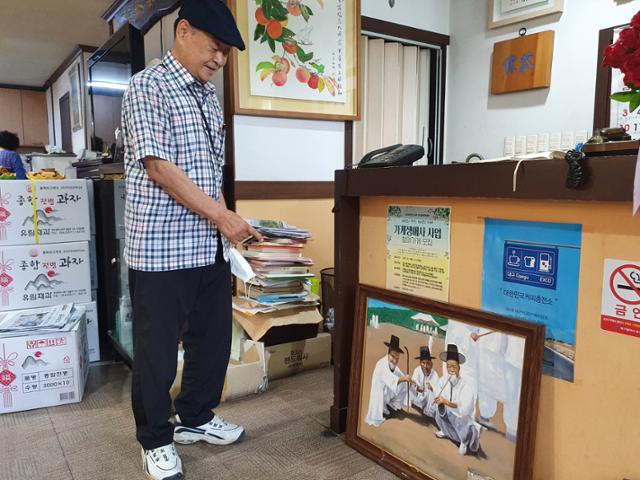 노씨중앙종친회 부회장인 노서구씨가 지난해 미도다방에 기증한 그림을 가리키며 미소 짓고 있다. 류수현 기자