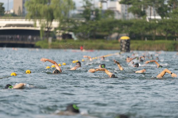 롯데월드타워가 7일 오전 서울 송파구 석촌호수에서 도심 속 이색 스포츠 대회 '2022 LOTTE Oe Race'를 개최했다. 참가자들이 석촌호수에서 수영 경기를 펼치고 있다.