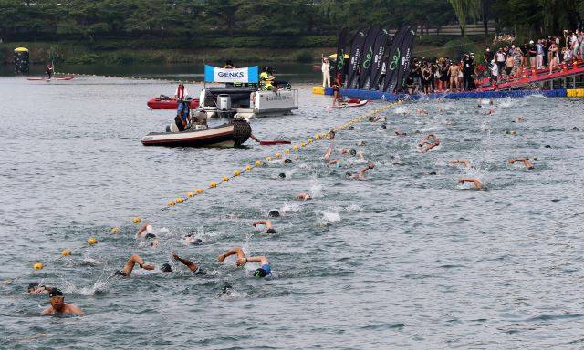7일 오전 서울 송파구 롯데월드타워 일대에서 열린 아쿠아슬론 대회인 Oe RACE에 출전한 참가자들이 석촌호수에서 수영하고 있다. 이한결 기자