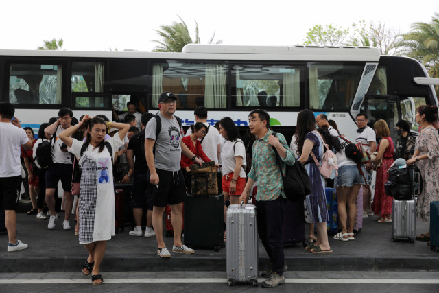 FILE PHOTO: People get off a coach at an entrance of Atlantis Sanya resort in Sanya, Hainan province, China November 25, 2020. Picture taken November 25, 2020. REUTERS/Tingshu Wang/File Photo