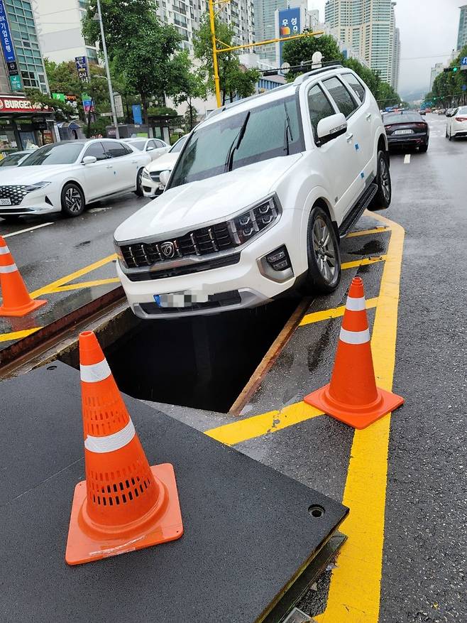 9일 오전 강남 대치역 사거리 인근 맨홀 뚜껑이 날아간 자리에 지나가던 차량의 바퀴가 빠지는 사고가 일어났다. / 독자 제공
