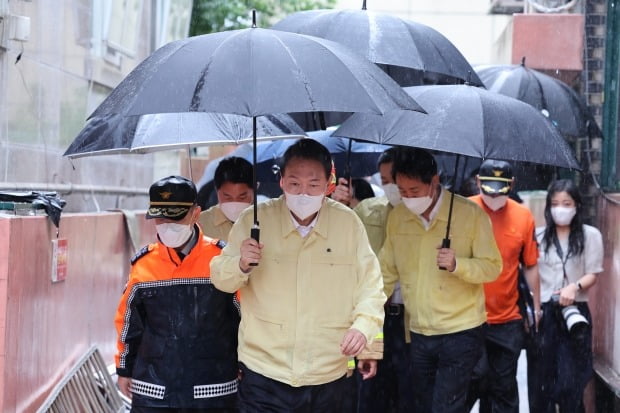 윤석열 대통령이 9일 발달장애인 가족이 폭우로 인한 침수로 고립돼 사망한 서울 관악구 신림동 침수 한 다세대주택을 방문한 뒤 다른 피해 현장으로 이동하고 있다. /사진=연합뉴스