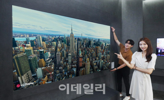 ▲10일 서울 코엑스에서 열린 ‘K-디스플레이 2022’에서 LG디스플레이 모델이 현존 최대 크기의 OLED TV 패널인 ‘97인치 OLED.EX’를 소개하고 있다. (사진=LG디스플레이)