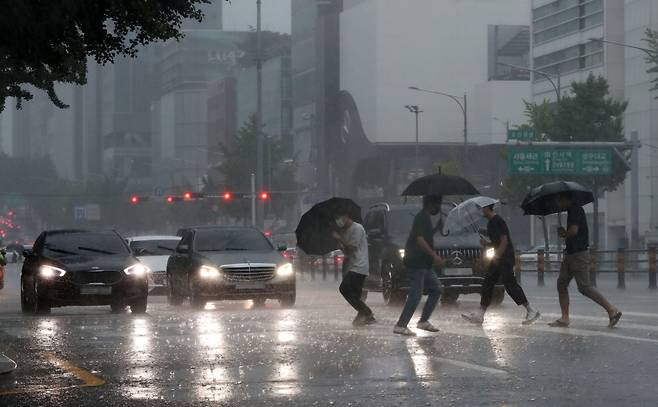 지난 8일 서울 강남구 도산대로 횡단보도에서 우산을 쓴 시민들이 발걸음을 재촉하고 있다. /뉴스1