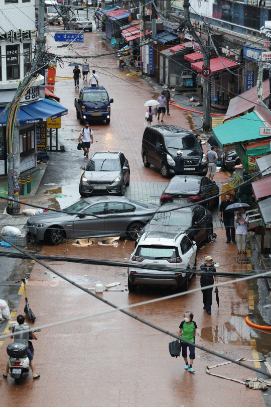 지난 9일 오전 서울 동작구 신대방 삼거리 인근 도로에 간밤의 폭우에 침수된 차들이 뒤엉켜 멈춰 서 있다. 연합뉴스