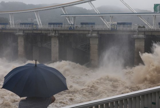 지난 6월 30일 하남시 팔당댐 근처에서 한 시민이 집중호우로 방류 중인 댐을 보고 있다. 연합뉴스