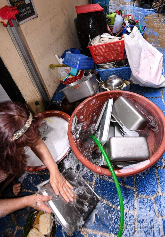 10일 서울 동작구 남성사계시장에서 한 음식점 관계자가 식기를 씻고 있다.