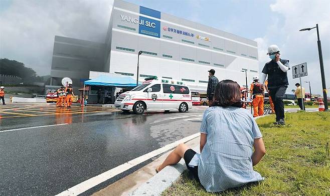 2020년 7월  경기 용인시 처인구 양지면 제일리 소재 SLC물류센터 앞에서 한 여성이 주저앉아 화재 현장을 바라보고 있다. 이날 불로 당시 근무하던 작업자 69명 중 지하 4층에 있던 5명이 숨지고 8명이 다쳤다. /연합뉴스
