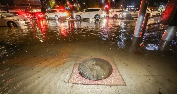 9일 새벽 폭우로 다수의 차량이 침수된 서울 강남구 대치사거리의 배수구가 뚜껑이 없어진 채 소용돌이치고 있다. 연합뉴스