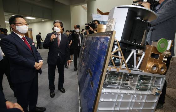 Daejeon Mayor Lee Jang-woo, left, listens to an explanation on satellite technology during a ceremony marking the 30th anniversary of the launch of Korea's first satellite, held at KAIST in Daejeon on Thursday. Korea's first satellite, named Wooribyeol I, was launched in French Guiana in South America in 1992. [NEWS1]
