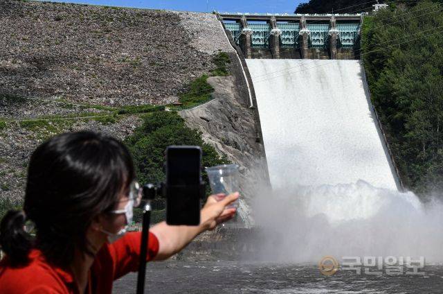 11일 강원도 춘천 소양강댐에서 강원도청 관계자가 투명 컵을 든 채 숏폼 콘텐츠를 제작하고 있다.