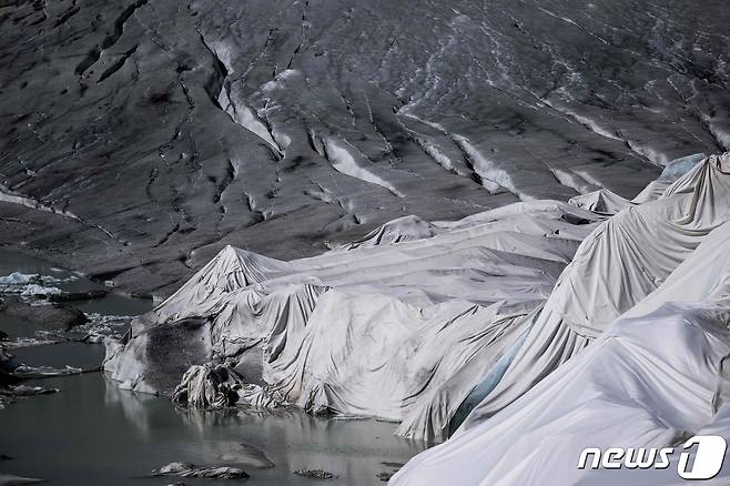스위스 산악 고갯길을 수세기 동안 덮고 있던 두꺼운 얼음층이 몇 주 안에 완전히 녹아버릴 것이라는 전망이 나왔다. 해당 사진에는 얼음이 녹는 것을 방지하기 위해 덮개로 덮어 놓은 모습이 찍혔다. ⓒ AFP=뉴스1 ⓒ News1 이서영 기자