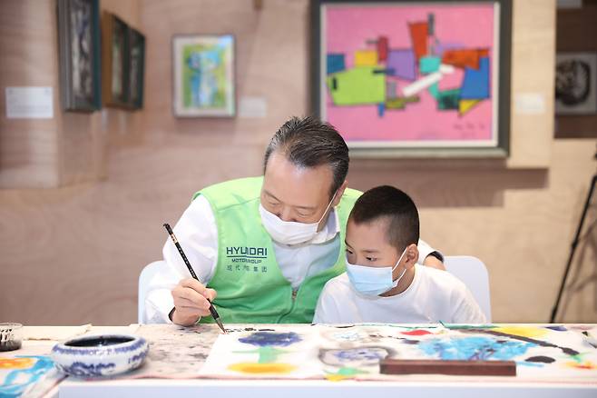이혁준 현대자동차그룹 중국 총재가 중국 베이징 798예술구에 있는 현대 모터스튜디오 베이징에서 뇌성마비장애아동과 함께 그림을 그리고 있다. 현대차는 지난해까지 중국 사회책임발전지수 평가에서 전체 기업 3위, 자동차 부문 6년 연속 1위, 외자 기업 6년 연속 2위에 올랐다.