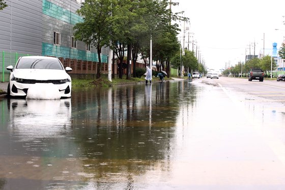 폭우 특보가 내려진 지난 11일 오후 전북 군산시 오식도동의 한 도로에서 군산시 공무원들이 배수 작업을 하고 있다. 연합뉴스