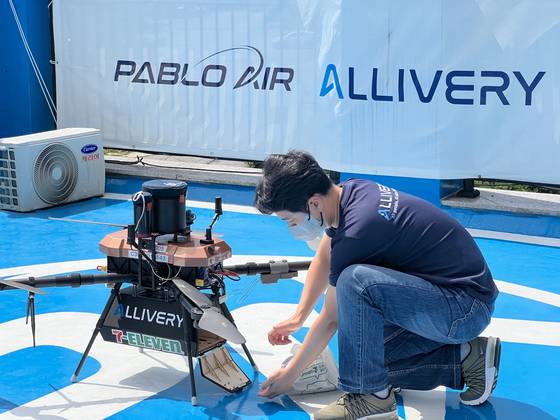 An employee loads the drone with items to be delivered. [LEE TAE-HEE]