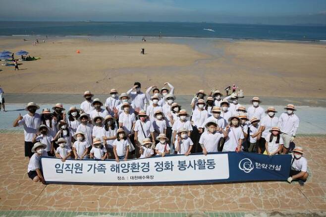 한화건설 임직원 가족들이 대천해수욕장 해양환경 정화 봉사활동에 참여하고 기념사진을 촬영하고 있다.   사진=한화건설 제공
